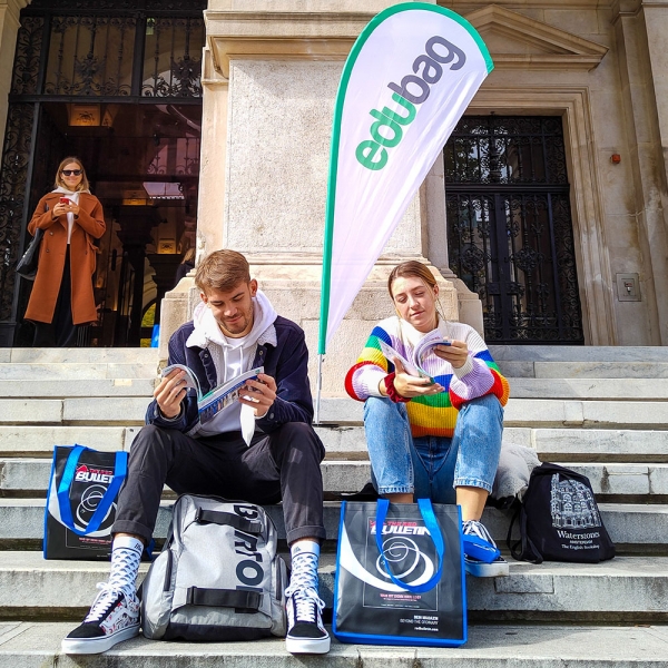 2 people with edubags sitting on Uni Vienna stairs looking through our edudeals vouchers