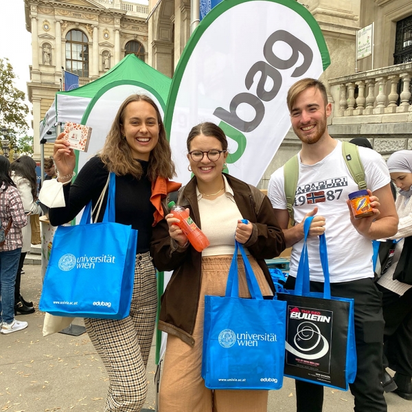 3 people with edubags holding various goodies